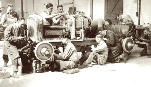 Dix mécaniciens s'affairent autour d'une Bentley 4 1/2 Litre Blower dans l'atelier de montage de Cricklewood.