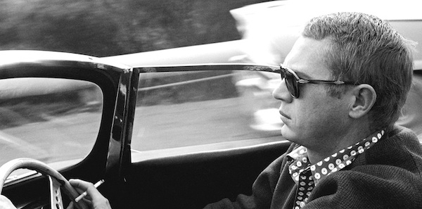 Steve McQueen s'offrant une petite balade à bord de sa Jaguar XKSS en 1960