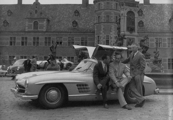 Les trois grands pilotes de l'écurie Mercedes-Benz, Stirling Moss, Juan Manuel Fangio et Karl Kring réunit autour d'une 300 SL Gullwing.